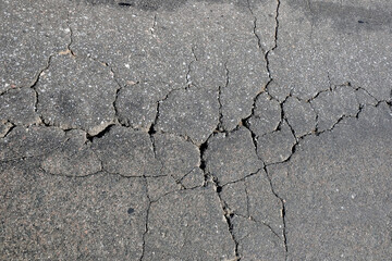 Asphalt surface of the roadway in bad condition needs repairs top view close up