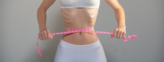 Weight loss, waist measurement, diet and health concept. Woman measuring her waist.