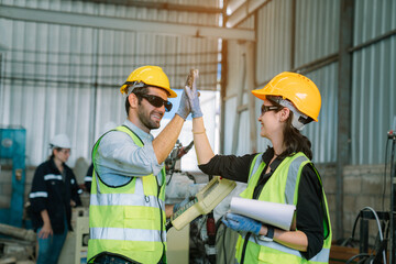 Team of Engineers is controlling robot arm machine welding steel, worker using forcing welding with a control screen which is used for precision welding control.	