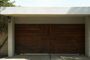 Beautiful new automated wooden gates and white wall outdoors