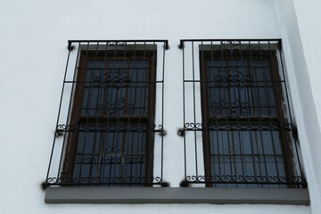 Exterior of building with beautiful window and steel grilles, low angle view