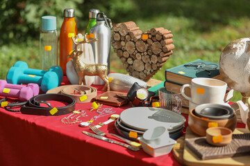 Many different items on table outdoors. Garage sale