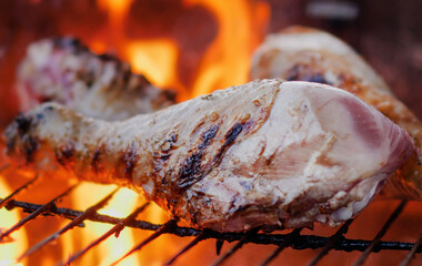Delicious marinated Turkey Drumsticks thighs on a wood grill in slow motion