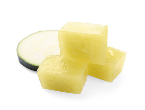 Frozen zucchini puree cubes and fresh zucchini isolated on white