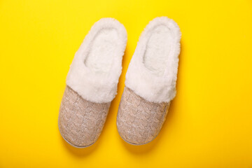 Pair of beautiful soft slippers on yellow background, top view