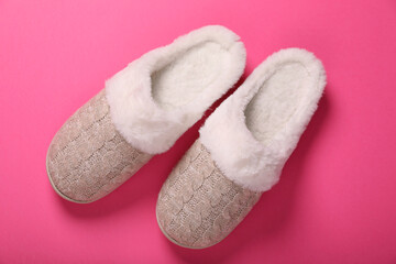 Pair of beautiful soft slippers on pink background, top view
