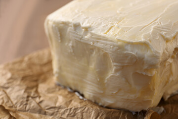 Piece of tasty homemade butter on parchment, closeup view