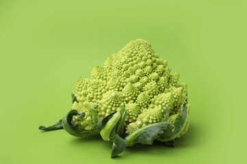 Fresh raw Romanesco broccoli on green background