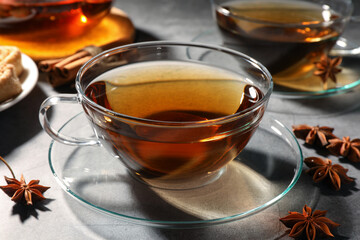 Aromatic tea with anise stars on light grey table, closeup