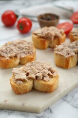 Tasty sandwiches with cod liver on white marble table