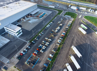 Aerial view of a factory and factory parking lot with cars and trucks parked