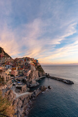 Fototapeta na wymiar Small touristic town on the coast, Manarola, Italy. Cinque Terre. Colorful Sunny Sunset Fall Season.