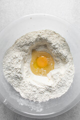 Fresh raw eggs in a bowl of flour, eggs sugar and flour in a mixing bowl, process for making biscotti