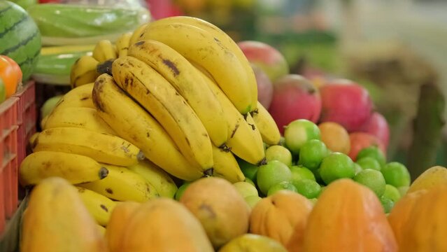 bunch of bananas in the foreground in the middle of a fruit and vegetable market