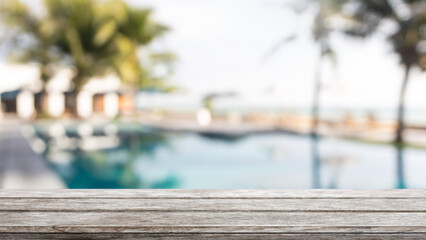 Empty wood table top and blurred swimming pool in tropical resort in summer banner background - can used for display or montage your products. - 560589210