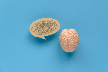 Concept of world mental health, problems ,mess in head pain feeling and hard thinking. Brain model and a bubble chat with a mess drawing.