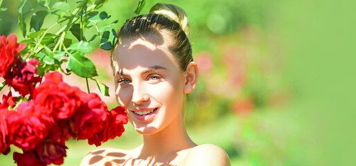 Portrait of sensual woman in spring background. Banner for website header. Happy girl in a garden with red roses. Beautiful young woman smelling a rose flower. - Powered by Adobe