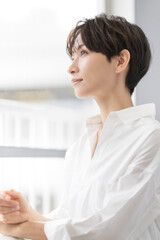 白いシャツを着たミドル女性のビューティーポートレート/自然光