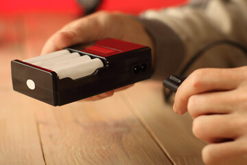 connecting power to the charger with batteries by a person