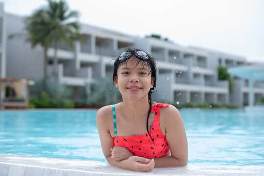 Happy girl enjoying summer vacations in a pool. Summer holidays, children's swimming, Pool woman on holidays in tropical resort swimming. summer vacation concept.
