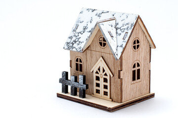 Obraz na płótnie Canvas Winter style model wooden house with snow on roof, wooden fence, door and window. Vintage wood home for decoration. Toy small property model isolated on white background. concept home buyer-seller.