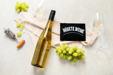 Glasses and bottle with white wine on a white background.