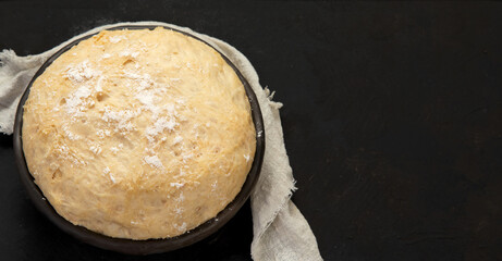 Raw dough pastry in a bowl on dark background.