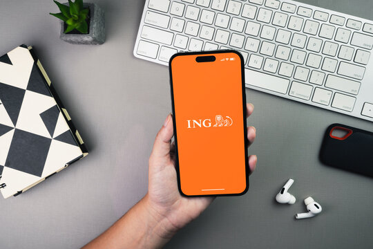 Girl holding a smartphone with ING bank app on the screen on grey background table. Office environment. Rio de Janeiro, RJ, Brazil. January 2023