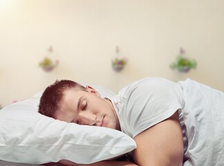 Young sleeping man in bed, hotel concept