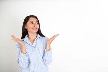 Portrait of a beautiful brunette woman in a blue shirt on a white background. Neutral makeup. Space for text