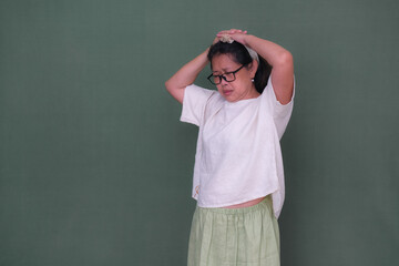 woman standing and pressing her head with both hands feeling dizzy