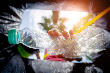 A young beautiful girl throws sorted garbage into special bins