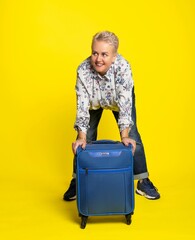 woman with a suitcase. Studio colored background. blue yellow. Happy, plump woman. bodypositive, big size, plus size