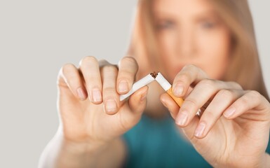 Stop smoking concept, young woman broken cigarette