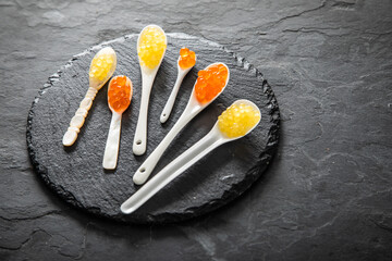 Kaviar von orange Keta Lachs und gelb Saibling mit Auswahl von Löffel aus Perlmutt, Plastik,...