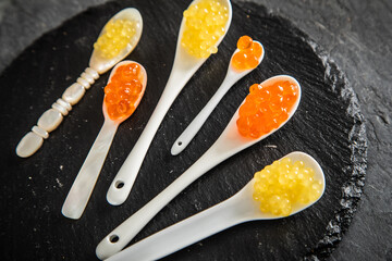 Kaviar von orange Keta Lachs und gelb Saibling mit Auswahl von Löffel aus Perlmutt, Plastik,...