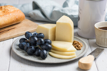 Traditional italian cheese Caciotta with grapes and walnuts, selective focus