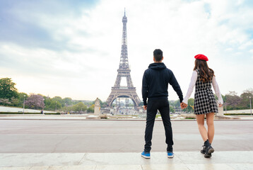 cheerful happy couple in love visiting Paris city centre and Eiffel Tower . american tourists travelling in Europe and dating outdoors
