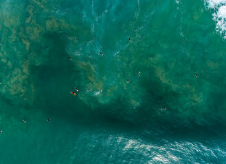 Aerial photography of group of surfers at beautiful waves of Atlantic Ocean, Portugal coastline.