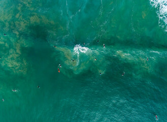 Aerial photography of group of surfers at beautiful waves of Atlantic Ocean, Portugal coastline.