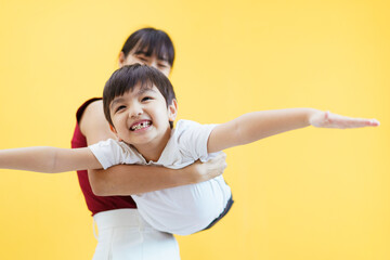 Happy cheerful Asian woman and a little young boy playing together.