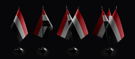 Small national flags of the Yemen on a black background