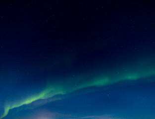 Fototapeta na wymiar Green and purple northern lights in iceland with the sky bluish by the moon