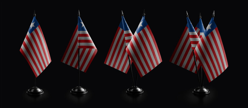 Small national flags of the Liberia on a black background