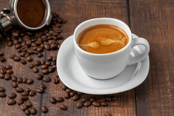 Fresh double espresso coffee and coffee beans on wooden table