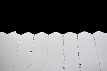 Close-up drops of rain fall from the roof, in the rainy season