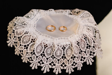 Engagement wedding rings. Gold couple rings on a plate. wedding ceremony in christian church. close up. Selective focus. Photo in motion.