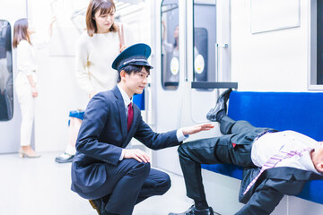 電車内倒れた乗客に声をかける車掌