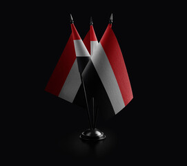 Small national flags of the Yemen on a black background