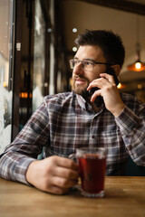 Bearded Man sitting alone at cafe or restaurant use smart phone